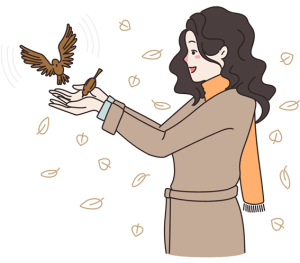 Uma mulher com as mãos estendidas dando alimento para dois pássaros